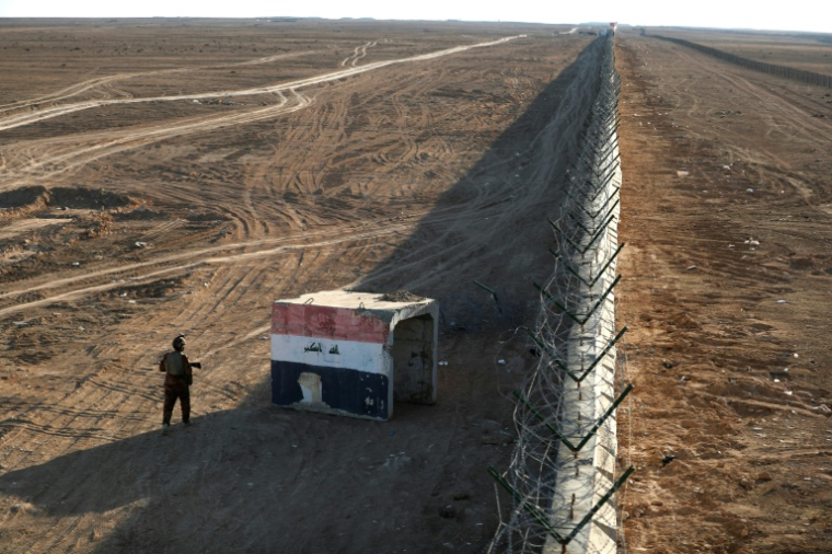 Un membre des forces frontalières irakiennes patrouille le long d'un mur en béton à la frontière irako-syrienne, le 21 janvier 2026 à al-Baghuz, dans le district d'Al-Qaim, dans l'ouest de l'Irak ( AFP / AHMAD AL-RUBAYE )
