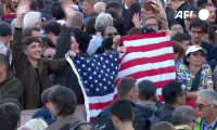 Des fidèles brandissent un drapeau américain sur la place Saint-Pierre