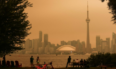 Le centre-ville de Toronto, au Canada, obscurci par les fumées dues à des feux de forêt dans le nord de la province de l'Ontario, le 15 juillet 2026 ( AFP / Cole BURSTON )