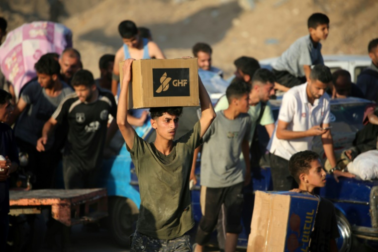Des Palestiniens rassemblés à un point de distribution d'aide de la Fondation humanitaire de Gaza (GHF), près du camp de réfugiés de Nousseirat, dans le centre de la bande de Gaza, le 25 juin 2025 ( AFP / Eyad BABA )
