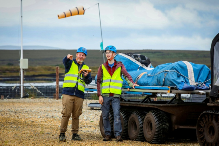 Le pilote Padraic Doherty, assisté par Jacob Hamilton, stagiaire, prépare le lancement d'un cerf-volant qui produit de l'électricité, à Bangor Erris, en Irlande, le 18 juillet 2025 ( AFP / Paul Faith )
