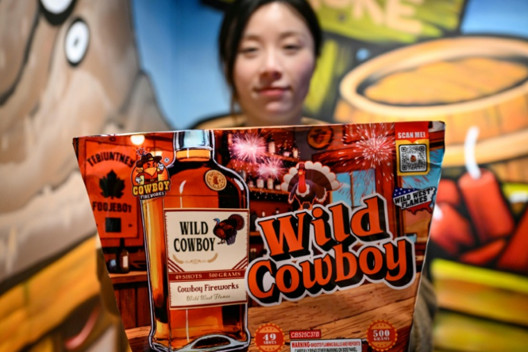 Une employée montre un paquet de feux d'artifice destinés au marché américain dans une galerie du groupe Zhongzhou Fireworks, à Liuyang, dans la province du Hunan, le 21 janvier 2026 en Chine ( AFP / Adek BERRY )