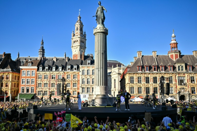 Les coureurs de l'équipe Visma - Lease a Bike saluent la foule au pied de la Colonne de la Déesse sur la Grand-Place de Lille lors de la présentation officielle des équipes, à Lille, dans le nord de la France, le 3 juillet 2025 ( AFP / Loic VENANCE )