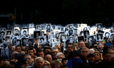 Des personnes tiennent des photos de victimes lors d'une cérémonie commémorant l'anniversaire de l'attentat à la bombe contre l'Association Mutuelle Israélite Argentine (AMIA) à Buenos Aires, le 18 juillet 2024 ( AFP / Tomas CUESTA )