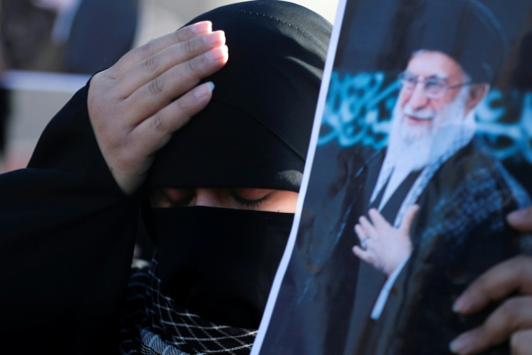 Une femme irakienne chiite se tient la tête en brandissant une photo du guide suprême iranien Ali Khamenei, tué la veille dans une opération israélo-américaine, le 1er mars 2026 à Bagdad ( AFP / AHMAD AL-RUBAYE )