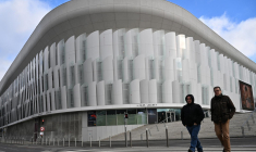 Des piétons marchent devant "Paris La Défense Arena", un stade couvert situé à Nanterre, en banlieue de l'ouest parisien. Photographie prise le 28 novembre 2023. ( AFP / MIGUEL MEDINA )