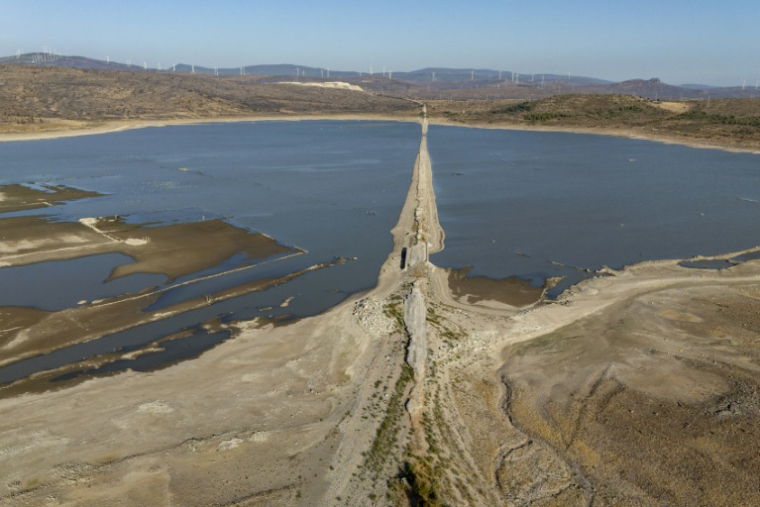 Vue aérienne montrant un tronçon de l'ancienne autoroute reliant Izmir à Cesme, en Turquie, émergeant en raison de la baisse de niveau de la retenue d'eau d'un barrage à Izmir, le 30 juillet 2025 ( AFP / Yasin AKGUL )