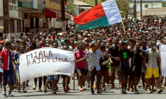 Des manifestants malgaches à Antsiranana brandissent le drapeau national et une banderole appelant le président Andry Rajoelina à partir, à Antananarivo le 1er octobre 2025 ( AFP / FITA )