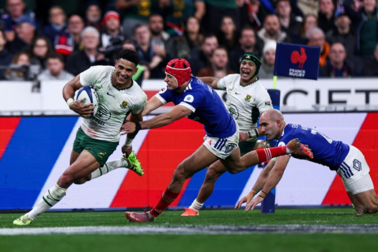 Sacha Feinberg-Mngomezulu échappe à Louis Bielle-Biarrey et Maxime Lucu pour aller marquer le 4e et dernier essai de la victoire des Springboks le 8 novembre 2025 au Stade de France ( AFP / FRANCK FIFE )