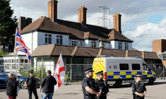 Des policiers devant l'hôtel Bell à Epping, au nord de Londres après que la cour d'appel a annulé une décision bloquant temporairement l'utilisation de l'établissement pour héberger des demandeurs d'asile, le 29 août 2025 ( AFP / CARLOS JASSO )