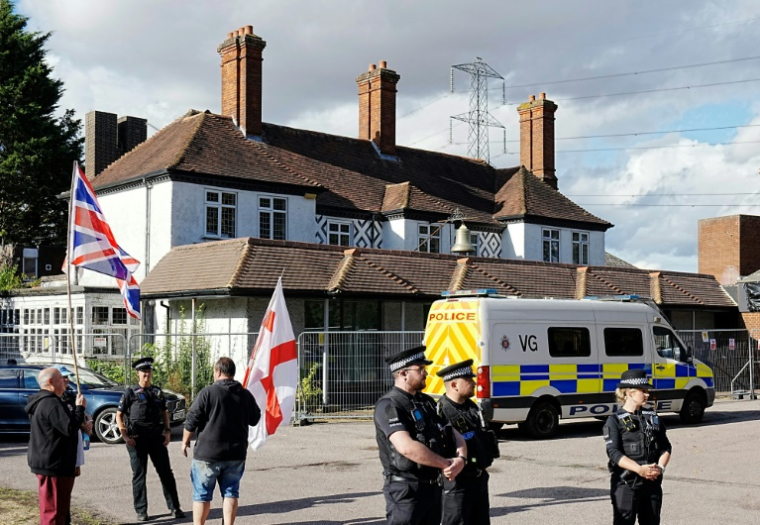 Des policiers devant l'hôtel Bell à Epping, au nord de Londres après que la cour d'appel a annulé une décision bloquant temporairement l'utilisation de l'établissement pour héberger des demandeurs d'asile, le 29 août 2025 ( AFP / CARLOS JASSO )
