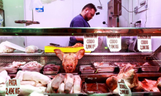 Un boucher manipule des morceaux de porc sur un étal de marché à Madrid