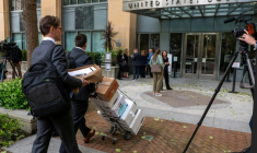 Des cartons de dossiers transportés au palais de justice des États-Unis à Oakland, où débute le procès Elon Musk contre Sam Altman, le 27 avril 2026 en Californie ( AFP / Karl Mondon )