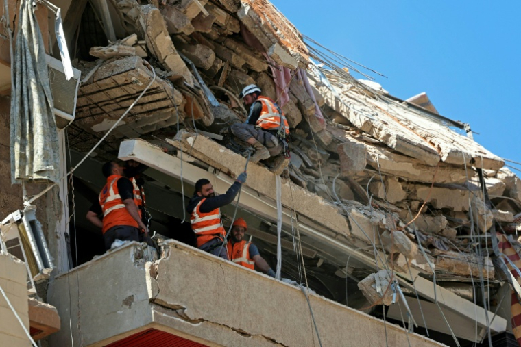 Des secouristes inspectent les décombres d'un bâtiment détruit par une frappe israélienne, le 7 mai 2026 dans la banlieue sud de Beyrouth ( AFP / Anwar AMRO )