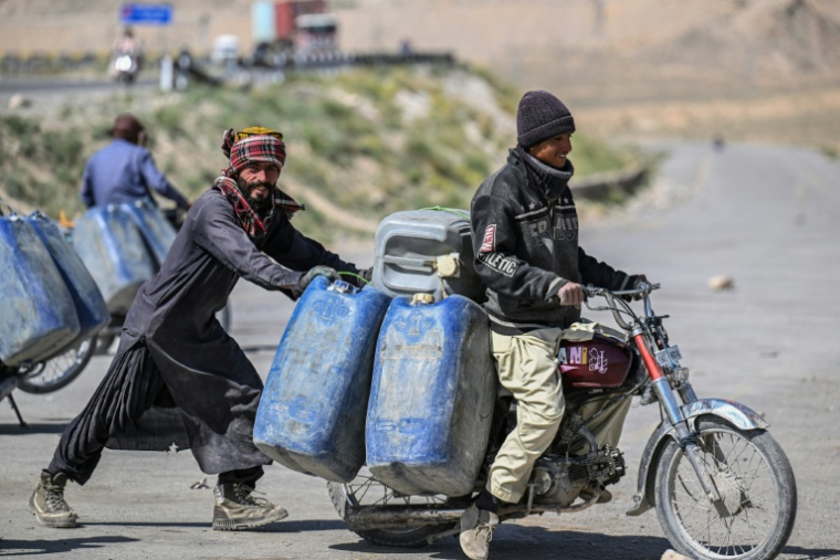 Des vendeurs transportent sur une moto des bidons d'essence iranienne de contrebande, à la périphérie de Quetta, dans la province du Baloutchistan,le 14 mars 2026 au Pakistan ( AFP / Banaras KHAN )