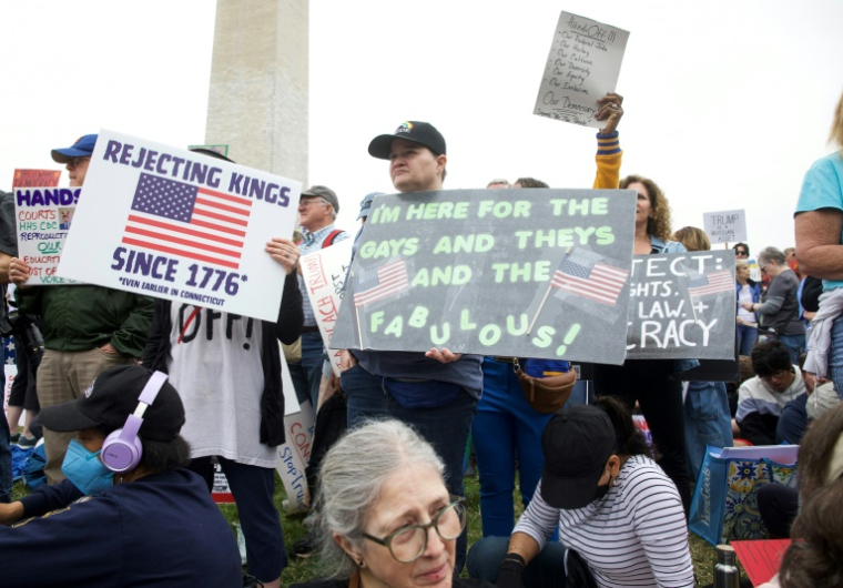 Des manifestants brandissent des pancartes sur le National Mall, à Washington, le 5 avril 2025 ( AFP / ROBERTO SCHMIDT )