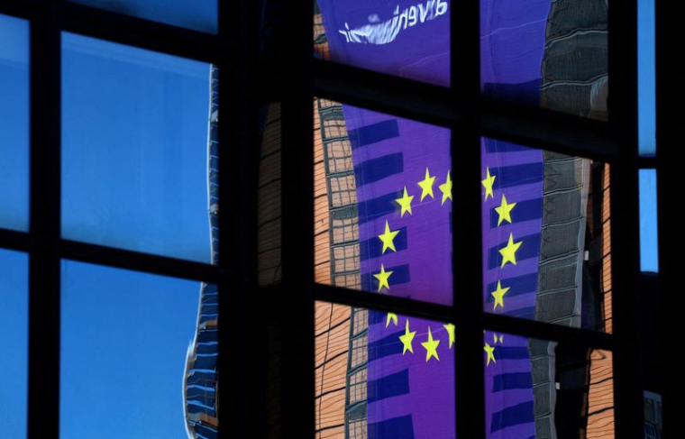 Une bannière représentant un drapeau de l'Union européenne se reflète dans une fenêtre à l'extérieur du siège du Conseil de l'Union européenne à Bruxelles