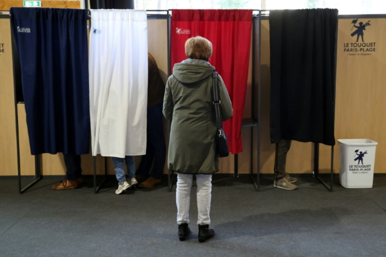 Une femme attend qu'un isoloir se libère pour voter au premier tour des élections municipales, le 15 mars 2026 au Touquet  ( AFP / Ludovic MARIN )