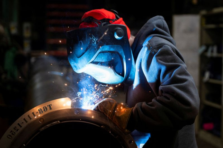 Un ouvrier soude un tube en acier