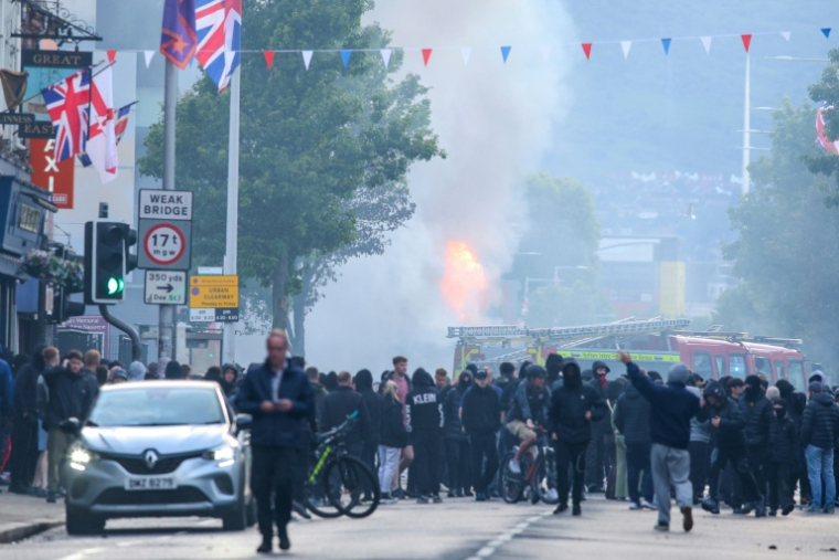 Un bus incendié alors que des manifestants se rassemblent sur la route de Newtownards, dans l'est de Belfast, en Irlande du Nord, le 9 juin 2026 ( AFP / Paul Faith )