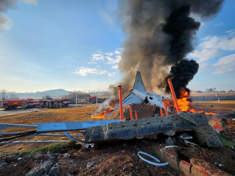 Des pompiers effectuent des opérations d'extinction sur un avion parti à la dérive à l'aéroport international de Muan, dans la province de Jeolla du Sud, en Corée du Sud