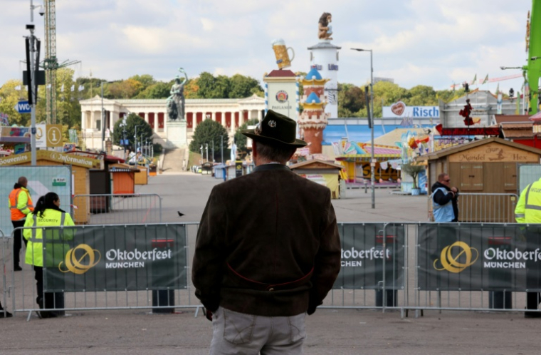 Un passant regarde le site de l'Oktoberfest, la grande Fête de la bière à Munich, fermé aux touristes après des menaces sur sa sécurité le 1er octobre 2025 à Munich (sud de l'Allemagne)  ( AFP / Alexandra BEIER )