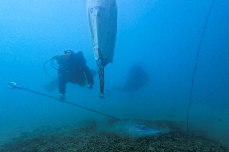 Des plongeurs professionnels installent un système d'amarrage écologique dans la baie de Porto Rafti, près d'Athènes, afin de protéger les herbiers de posidonie sensibles des fonds marins, le 11 février 2026 en Grèce ( AFP / Will VASSILOPOULOS )