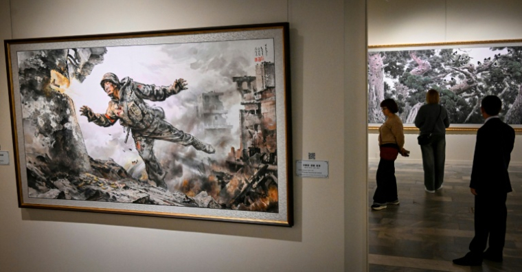Des visiteurs à l'exposition de peintures nord-coréennes au musée des arts décoratifs de Moscou, le 2 octobre 2025  ( AFP / Alexander NEMENOV )