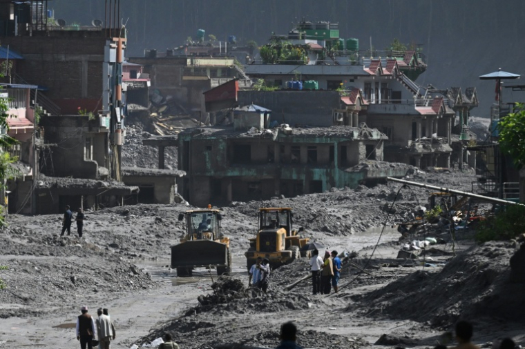 Des pelleteuses déblaient la boue et les gravats après la crue destructrice dans l'Himalaya, le 30 août 2026 à Trishuli, dans le district népalais de Nuwakot  ( AFP / Arun SANKAR )