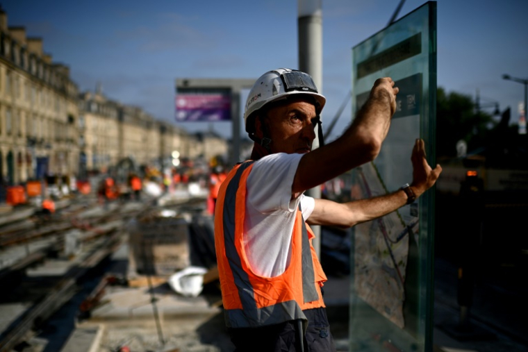 Un ouvrier travaillante sur un chantier de lignes de tramway le long de la Garonne se protège du soleil pendant une vague de chaleur à Bordeaux, dans le sud-ouest de la France, le 1er juillet 2025 ( AFP / Christophe ARCHAMBAULT )