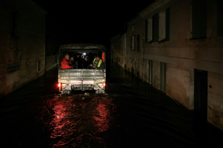 Des habitants de Courcoury (Charente-Maritime) transportés par un véhicule de la gendarmerie en raison des inondations, le 23 février 2026 ( AFP / Philippe LOPEZ )