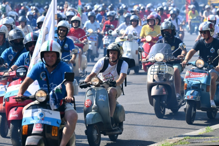 Des passionnés de Vespa du monde entier participent à la parade des Vespa World Days, marquant le 80e anniversaire de la célèbre marque italienne de scooters, le 27 juin 2026 à Rome  ( AFP / Alberto PIZZOLI )
