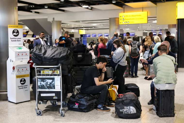 Des voyageurs attendent près de la zone d'enregistrement de British Airways à l'aéroport d'Heathrow