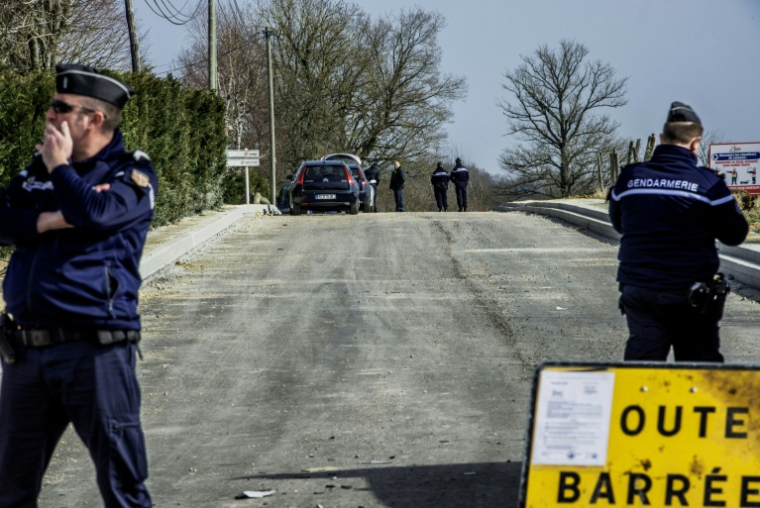 Des gendarmes bouclent le secteur où ont été retrouvés des fourgons brûlés à Avallon, dans l'Yonne, après un braquage, le 11 mars 2015 ( AFP / JEFF PACHOUD )