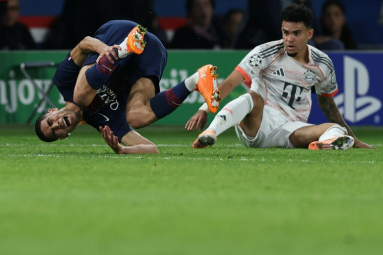 Le défenseur du Paris SG Achraf Hakimi (G) blessé lors de la défaite contre le Bayern Munich (2-1) à la suite d'un tacle de l'attaquant Luis Diaz (D), le 4 novembre 2025 au Parc des Princes ( AFP / Thomas SAMSON )