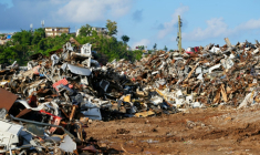 Un terrain jonché de débris et de tôles métalliques à Mamoudzou, un an après le passage du cyclone Chido à Mayotte, le 2 décembre 2025 ( AFP / Marine GACHET )