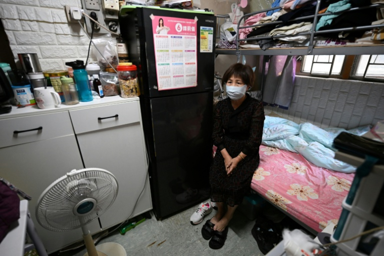 Une femme dans son logement d'un appartement subdivisé, le 30 avril 2026  à Hong Kong ( AFP / Peter PARKS )