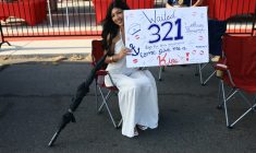 Une femme attend un membre de sa famille, militaire embarqué à bord du porte-avions USS Abraham Lincoln, dans le port de San Diego, en Californie, le 8 octobre 2026 ( AFP / David Swanson )