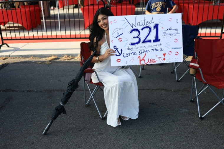 Une femme attend un membre de sa famille, militaire embarqué à bord du porte-avions USS Abraham Lincoln, dans le port de San Diego, en Californie, le 8 octobre 2026 ( AFP / David Swanson )