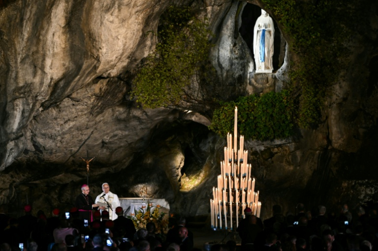 Le pape Léon XIV préside une prière avec des fidèles aux côtés de l'archevêque italien Diego Ravelli (à gauche) à la grotte de Massabielle, dans le sanctuaire de Notre-Dame de Lourdes, le 26 septembre 2026 ( AFP / Lionel BONAVENTURE )