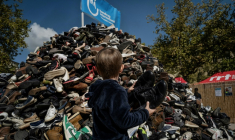 Un enfant jette une paire de chaussures à l'occasion du 30e anniversaire de la pyramide de chaussures de Handicap international (HI), le 27 septembre 2025 à Lyon ( AFP / JEFF PACHOUD )