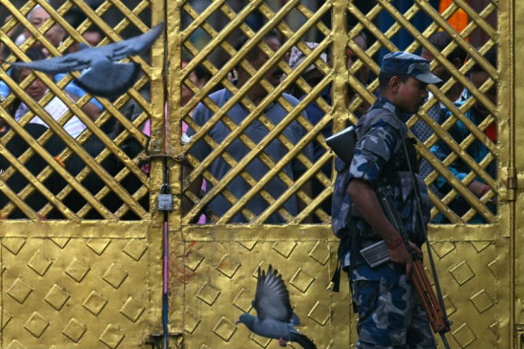 Un membre des services de sécurité en faction devant un temple, le 14 septembre 2025 à Katmandou ( AFP / Arun SANKAR )