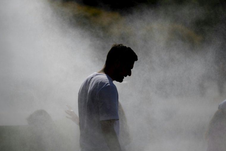 Un homme marche sous un système de brumisation installé lors d'une vague de chaleur à Strasbourg, dans l'est de la France, le 20 juin 2026 ( AFP / ROMEO BOETZLE )