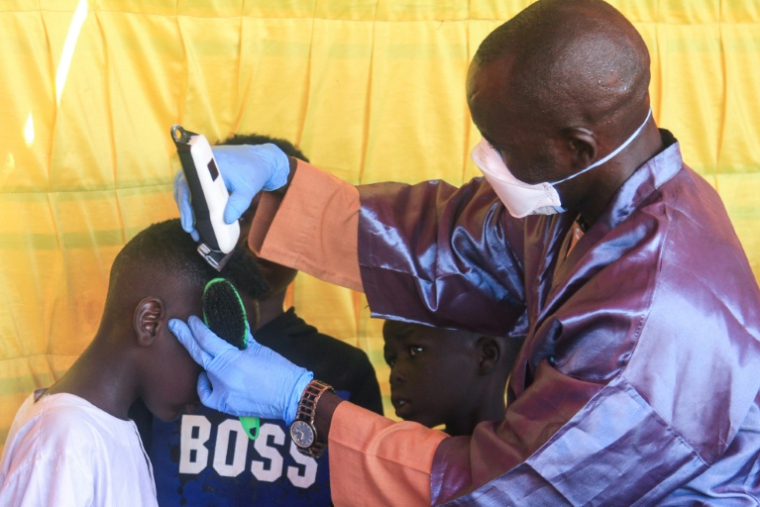 Des garçons soudanais originaires d'El-Facher, dans l'ouest du Soudan, se font couper les cheveux dans un camp pour personnes déplacées dans la ville d'Al-Dabbah, dans le nord du Soudan, le 22 novembre 2025 ( AFP / Ebrahim Hamid )