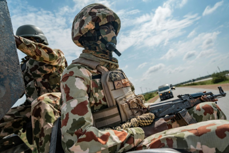 Un soldat nigérian à l'arrière d'un véhicule d'escorte militaire sur l'autoroute reliant Maiduguri à Damaturu, au Nigeria, le 31 juillet 2026. ( AFP / - )