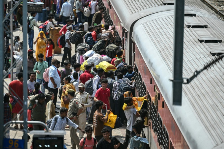 Des habitants tentent de monter dans un train surchargé à la gare de Jammu, le 10 mai 2025 au Cachemire indien ( AFP / Money SHARMA )