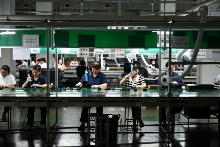 Des ouvriers produisent des dispositifs de sécurité à l'usine taïwanaise Xingbao Plastic Products Co. Ltd. à Kunshan, dans la province orientale du Jiangsu, le 10 juin 2025 en Chine ( AFP / GREG BAKER )
