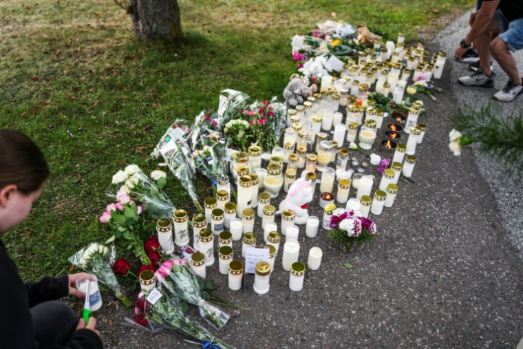 Des bougies et des fleurs disposées devant le lycée où une attaque à l'épée a coûté la vie à une élève de 17 ans et fait trois blessés, le 22 août 2026 à Fagersta, dans le centre de la Suède ( TT NEWS AGENCY / Magnus LEJHALL )