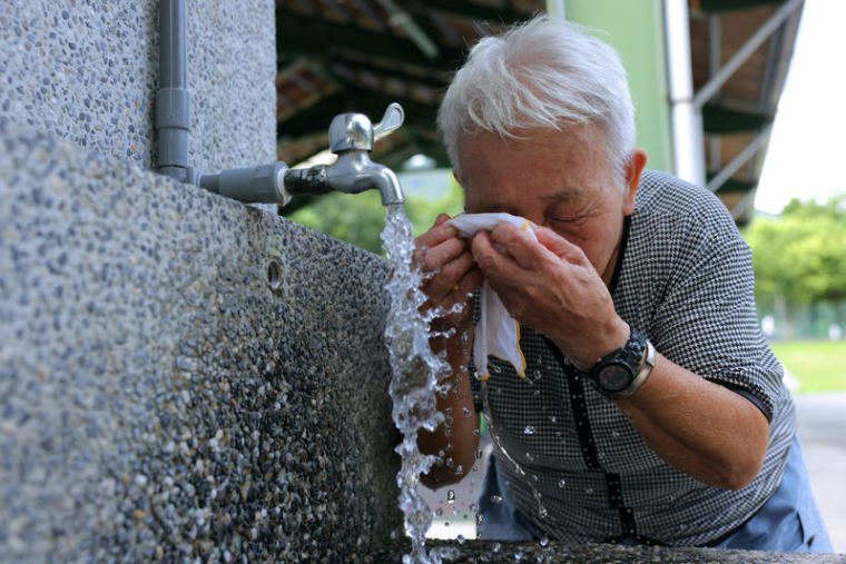 Une personne âgée se rafraichie lors d'une journée de canicule