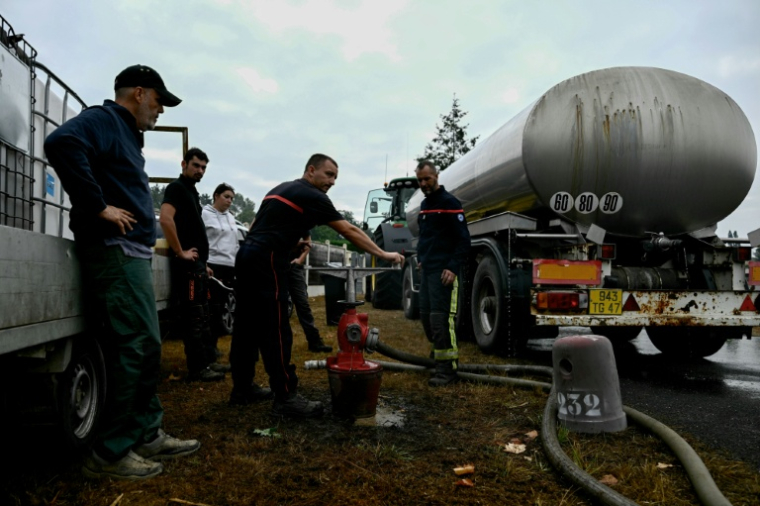Des agriculteurs aident les pompiers à remplir des citernes pour lutter contre l'incendie en Gironde, à Blagon, à l'ouest de Bordeaux, le 27 juillet 2026 ( AFP / Philippe Lopez )